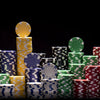 Striped dice poker chips shown stacked with a black background.