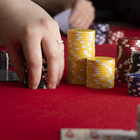 Striped dice poker chips stacked in play on a poker table.
