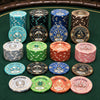A set of Gatsby Room ceramics poker chips arranged in rows on a green felt table, including blue, teal, black, brown, green, orange, pink, and silver stacks with denominations from 25 to 5000.