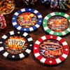 Giant poker chip drink coasters with colorful designs on a wooden table with drinks and cards.