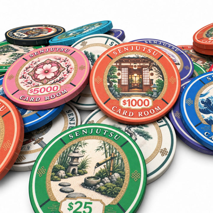 A pile of colorful Senjutsu Card Room ceramic poker chips on a white background, featuring designs inspired by Japanese culture including Mount Fuji, The Great Wave off Kanagawa, and a garden scene.