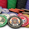 A collection of colorful casino grade ceramic poker chips with Japanese-themed Senjutsu Card Room design and denominations like $25, $100, and $500, arranged in stacks and scattered on a white background.